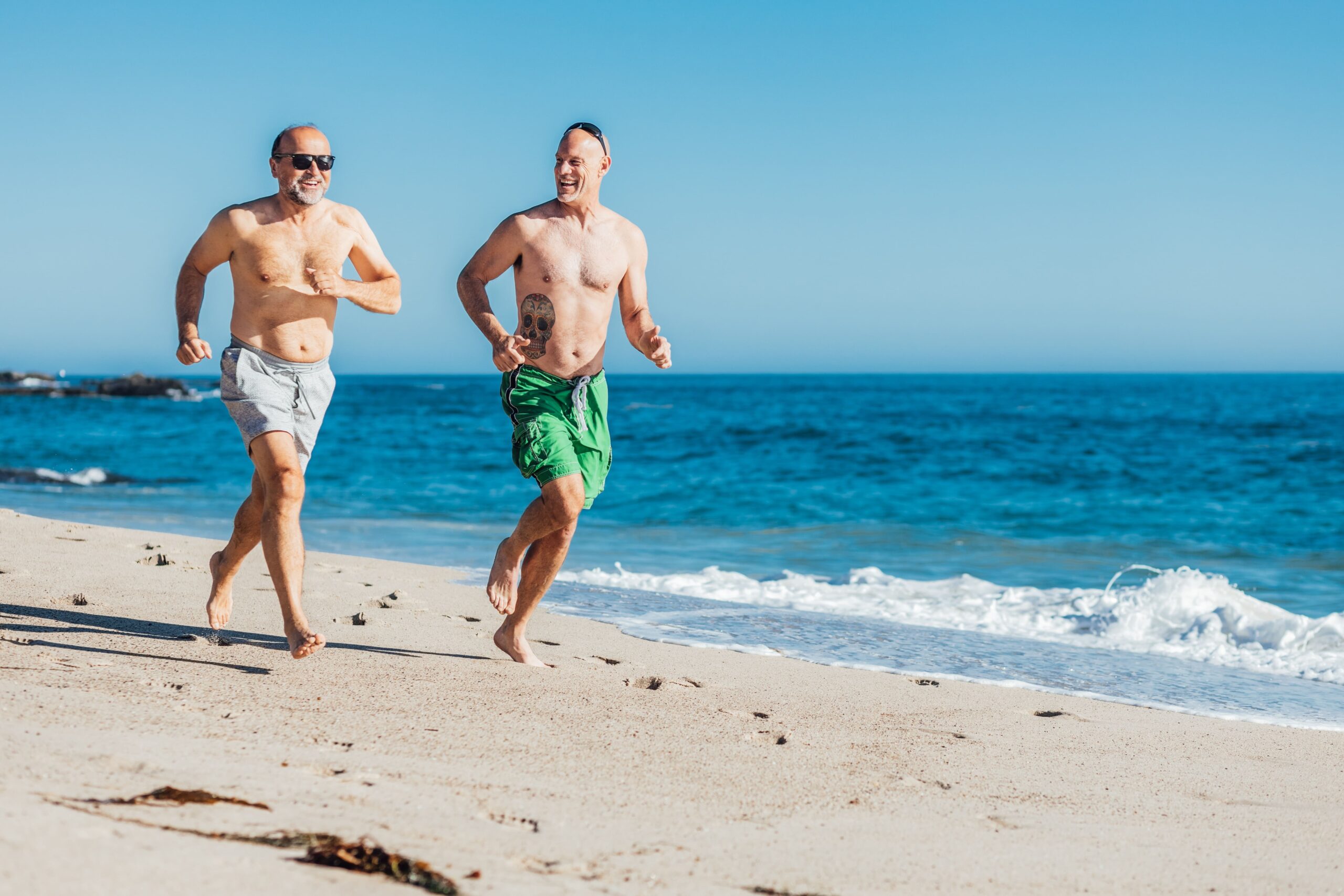 Two old adults running on the beach