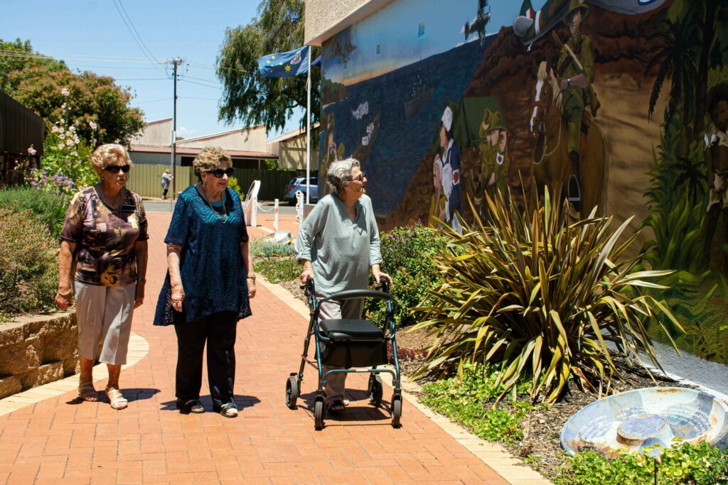 senior women walking and observing mural